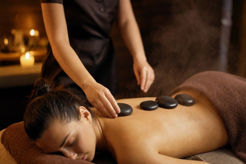 Massagem com pedras quentes colocadas ao longo das costas