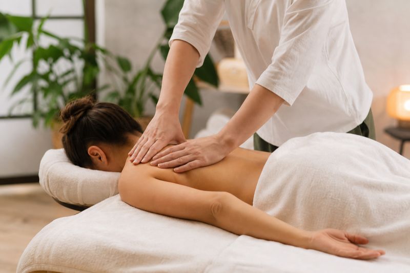 Profissional aplicando massagem shiatsu nas costas do cliente
